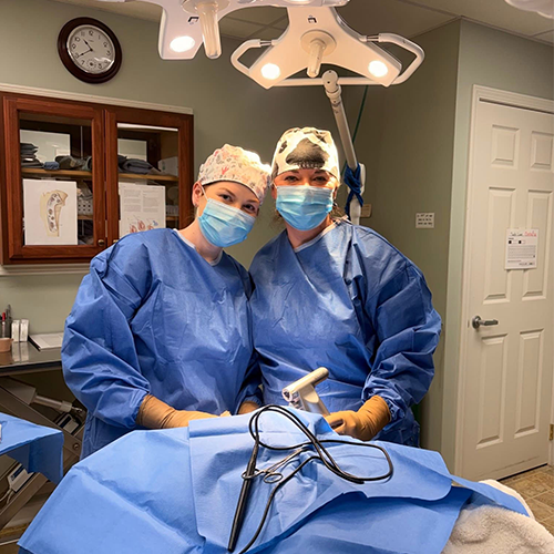 Two surgeons stand together in an operating room